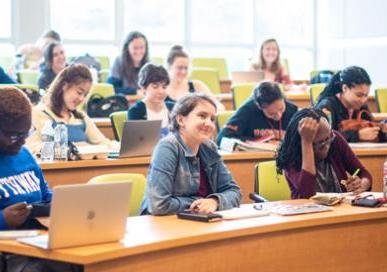 Students with laptops in a classroom learning